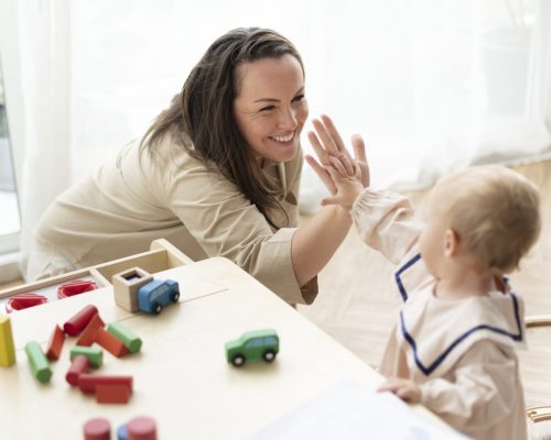 Mother and baby daughter giving high fives